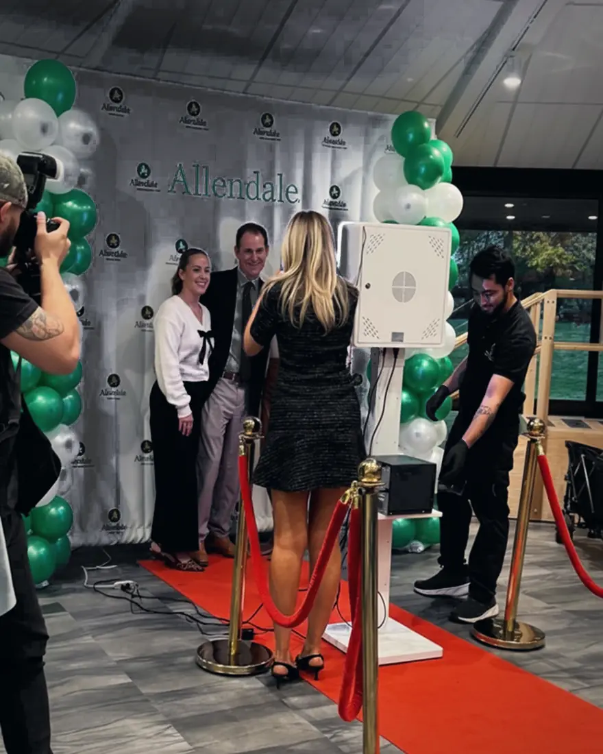 Guests at the photo booth with a red carpet and balloon columns
