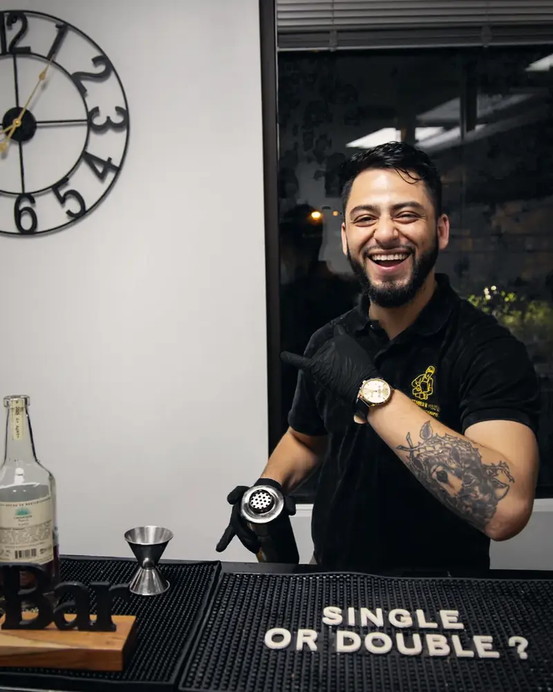Bartender laughing behind the bar at the end of the night